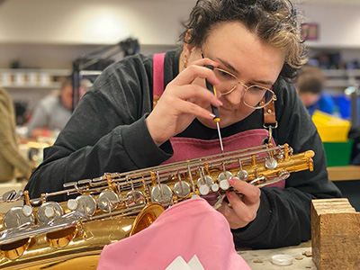 Student working on a saxophone. 