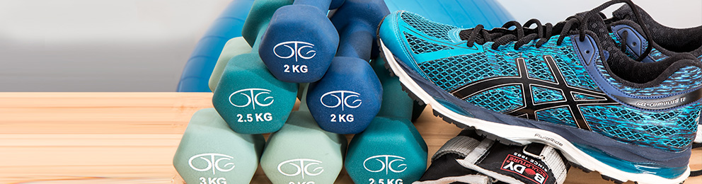 A tennis shoe next to some small workout weights