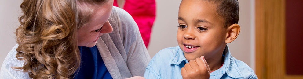 Teacher talking to smiling child