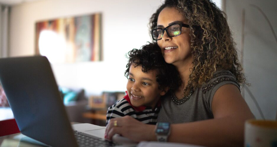 Adult learner and child looking at laptop