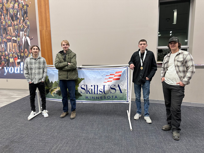 Four Southeast autobody students pose for a photo by the Skills USA banner at the Skills USA Auto Body Competition