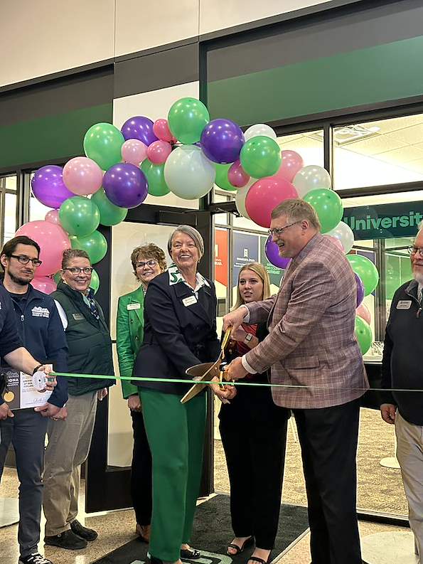 Southeast President Marsha Danielson and Winona State President Ken Janz jointly hold a pair of over-sized scissors as they prepare to cut the ribbon for the new University Center on Southeast's Winona campus.