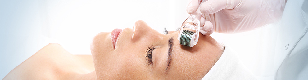 Gloved hand using a roller on the forehead of a placid client