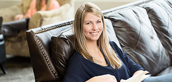 Student on couch with a book
