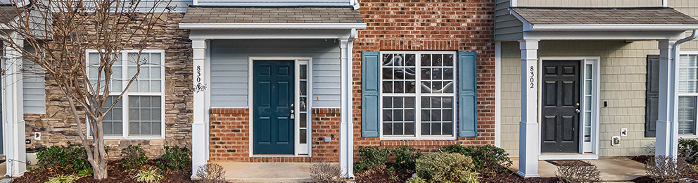 row of townhomes with exterior front door and main floor windows 