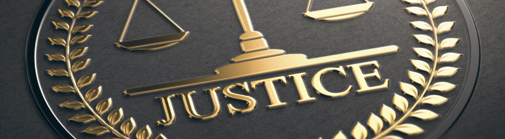 Closeup of embossed logo with the word Justice, scales, and laurel leaves