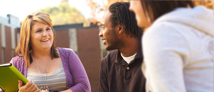 Counselor talking to two students outside